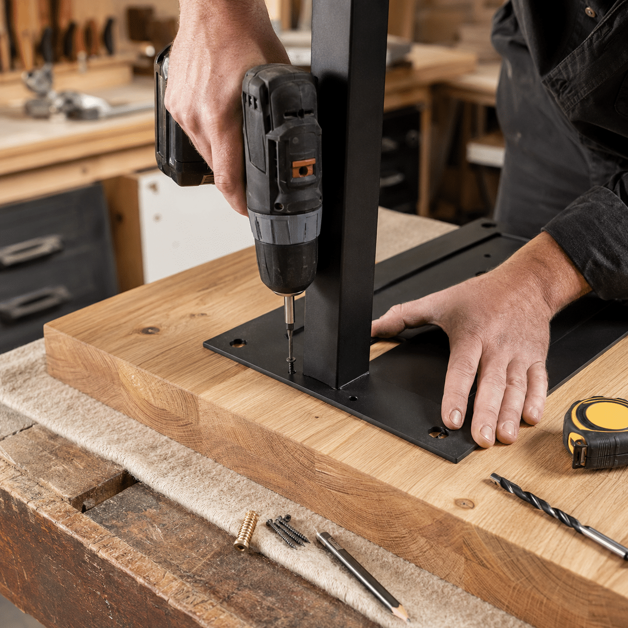 Fixation d’un plateau de table en bois sur une platine de pied en métal avec une visseuse